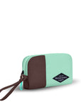 Angled front view of Sherpani travel accessory, the Jolie in Seagreen, in small size. The pouch is two-toned in light green and brown. It features a brown wristlet strap and an easy-pull zipper accented in light green.