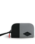 Flat front view of Sherpani travel accessory, the Jolie in Stone, in small size. The pouch is two-toned in gray and black. It features a black wristlet strap and an easy-pull zipper accented in red.