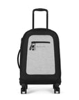 Flat front view of Sherpani’s Anti-Theft luggage the Latitude in Sterling. The suitcase has a soft shell exterior made from recycled plastic bottles and features vegan leather accents in black. There is a main zipper compartment, an expansion zipper and an external pocket on the front with a locking zipper and a ReturnMe tag. On the top of the suitcase sits a retractable luggage handle. On the side sits an easy-access handle. At the bottom are four 360-degree spinner wheels for smooth rolling.