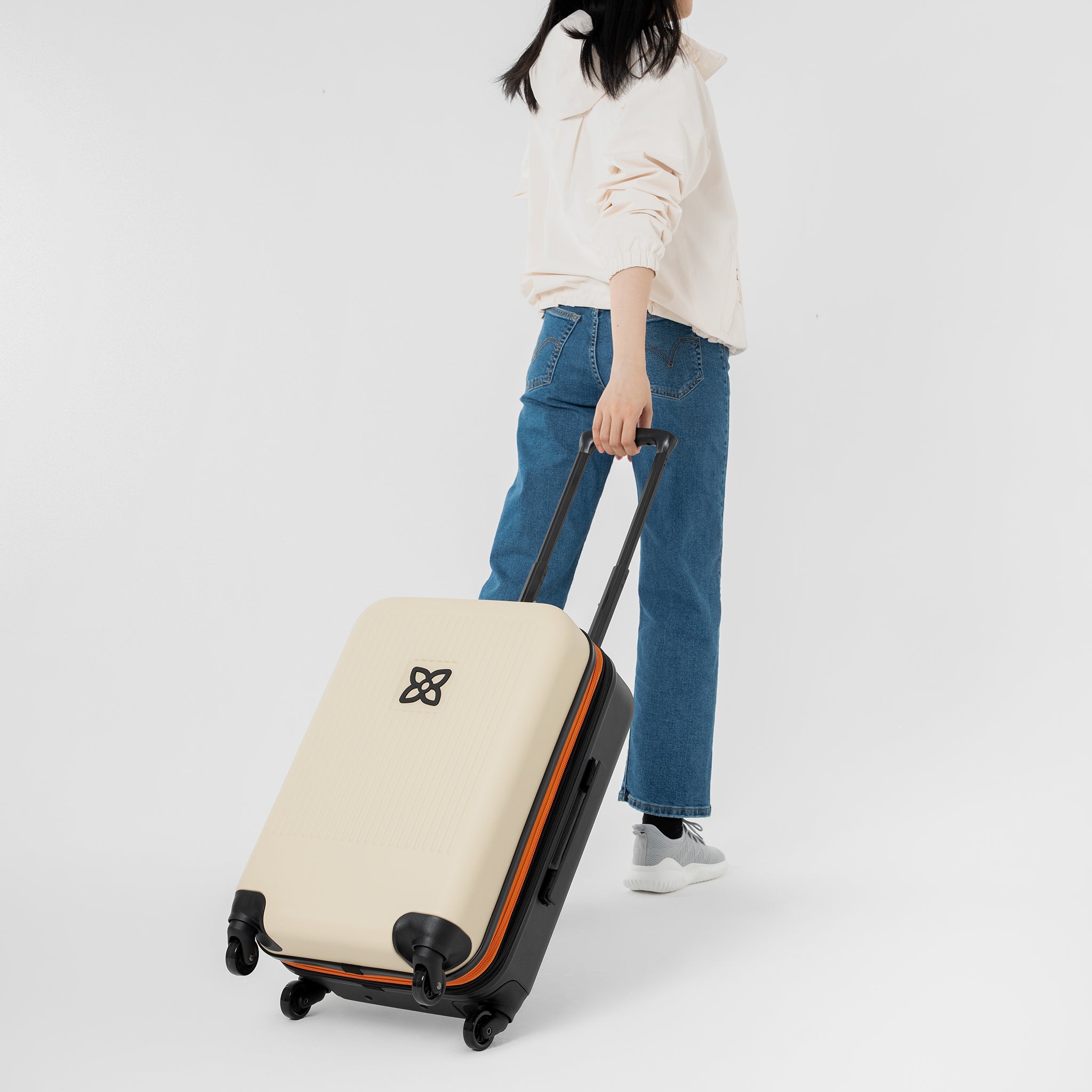 A model pulls Sherpani hard-shell luggage, the Meridian in Bluff, behind her. 