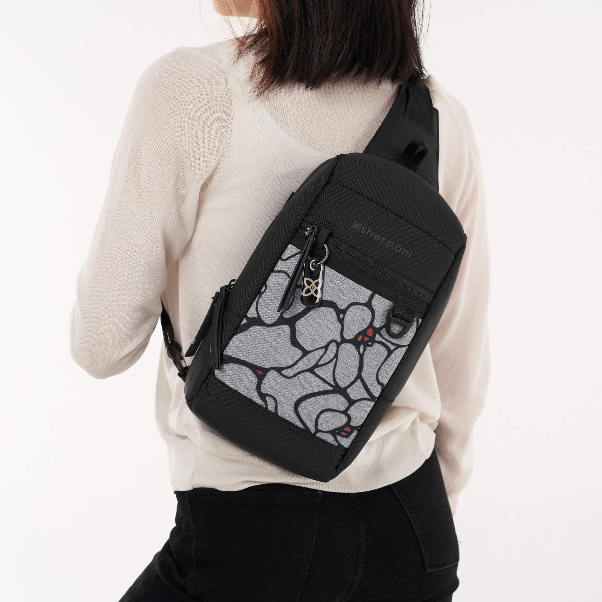 Model wearing mini travel sling backpack, the Metro in Sakura. 