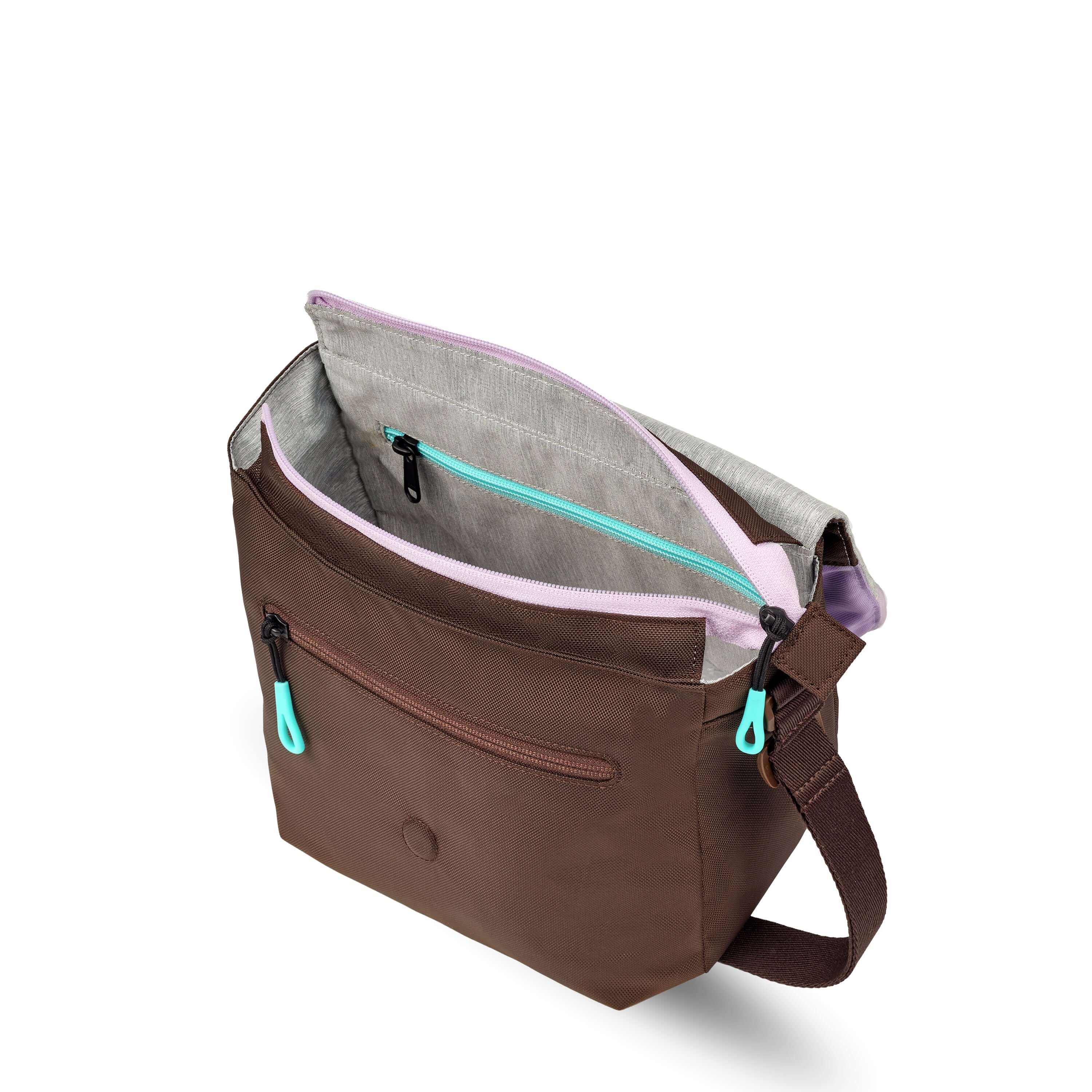 Top view of Sherpani crossbody, the Milli in Lavender. The layover flap is folded all the way back and the main zipper compartment of the bag is open. The interior is light gray and features an internal zipper pocket.