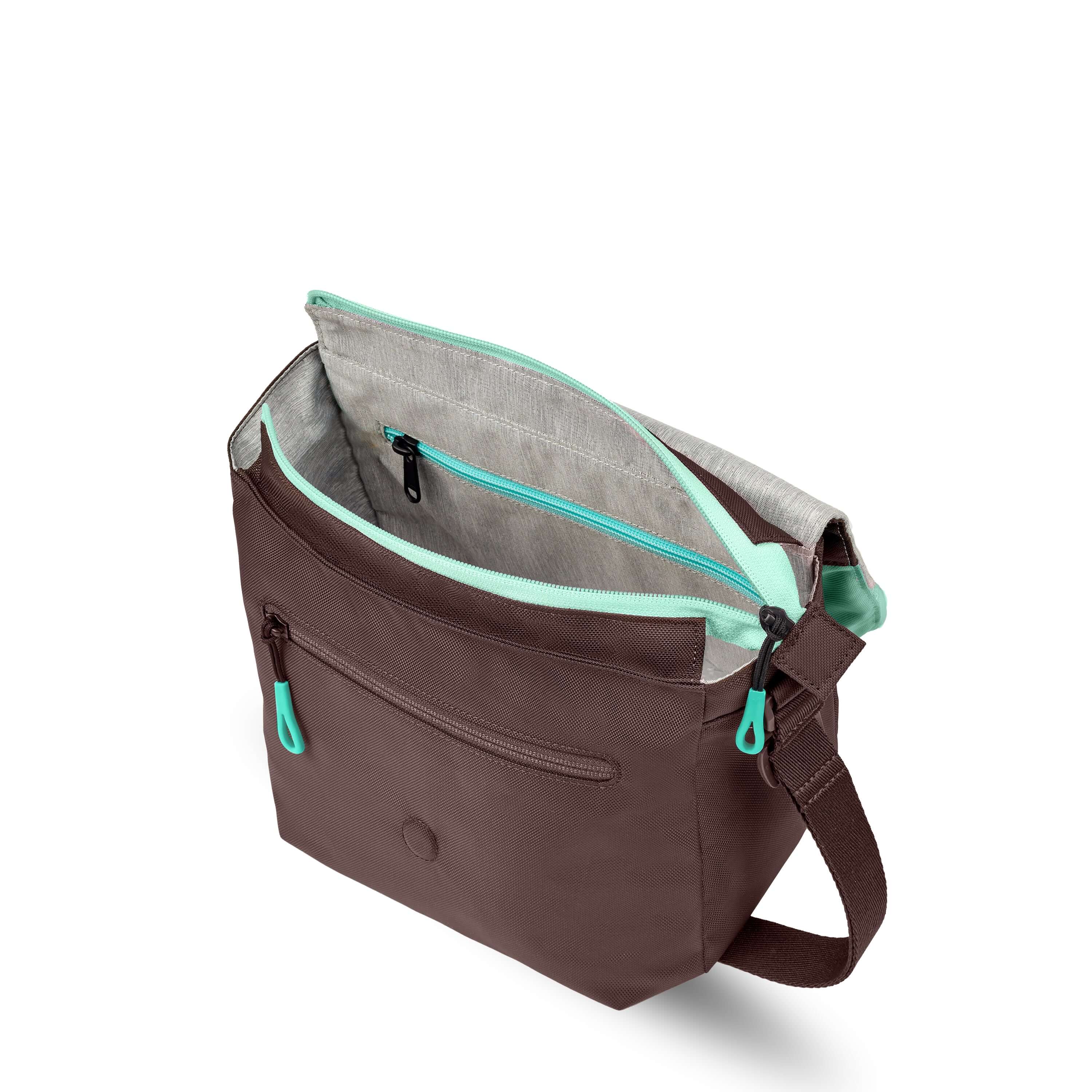 Top view of Sherpani crossbody, the Milli in Seagreen. The layover flap is folded all the way back and the main zipper compartment of the bag is open. The interior is light gray and features an internal zipper pocket.
