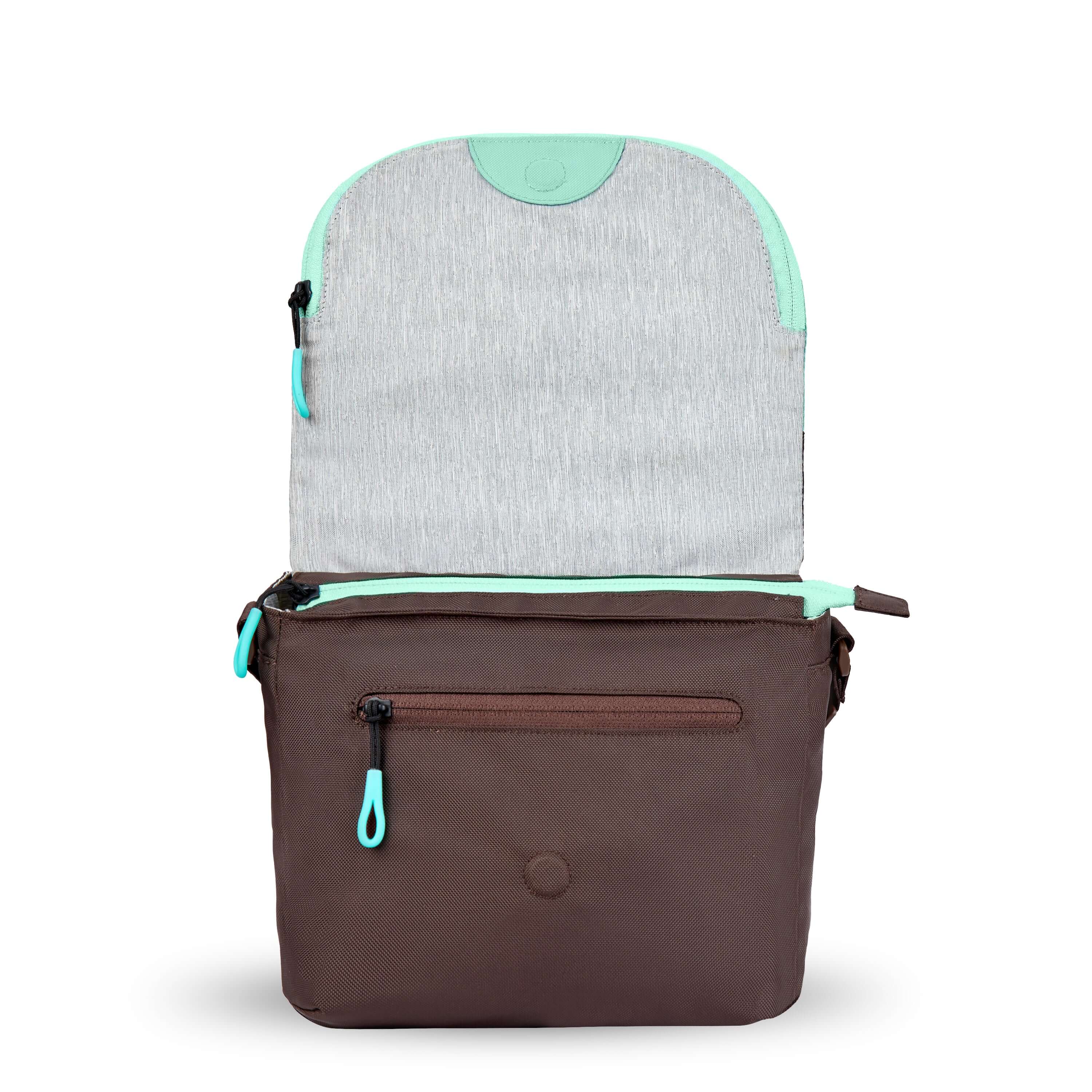 Front view of Sherpani crossbody, the Milli in Seagreen. The layover flap is standing tall to reveal an external zipper pocket and a small magnet that holds the flap down.