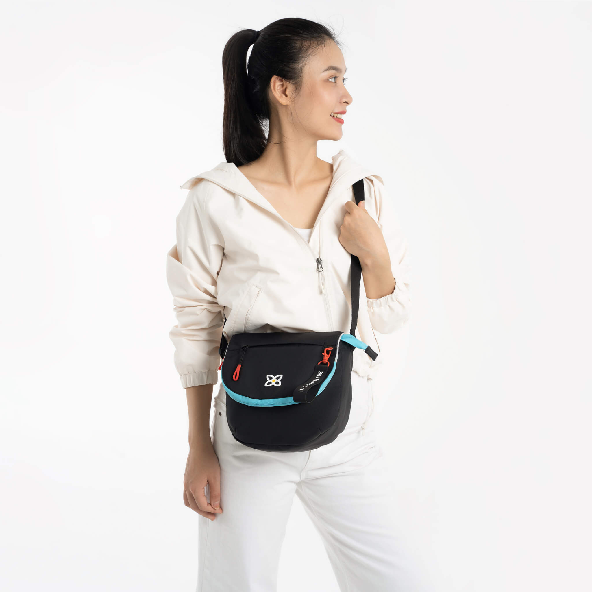 A model showing Sherpani satchel style purse, the Milli in Chromatic. 