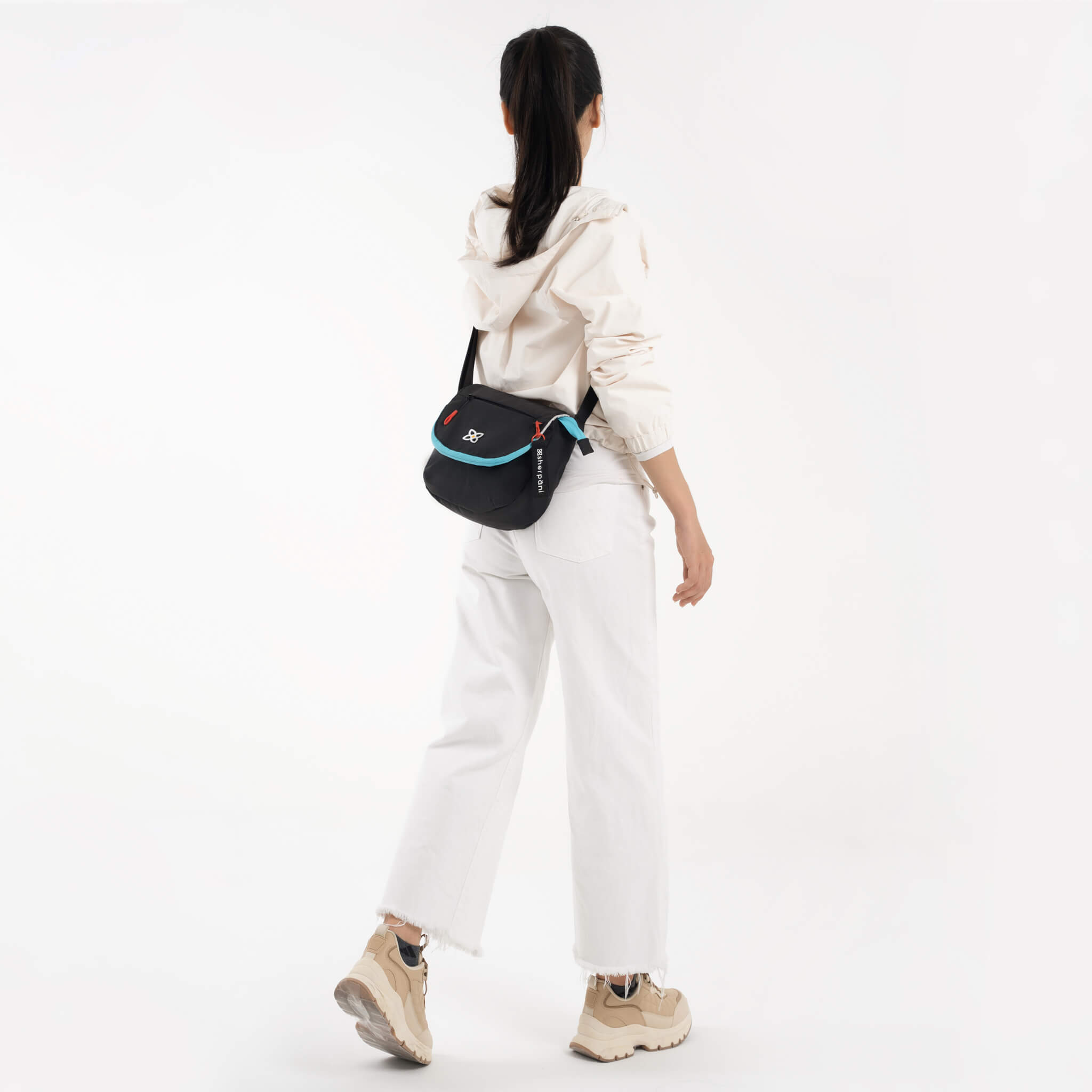 A model wearing Sherpani satchel crossbody bag, the Milli in Chromatic. 