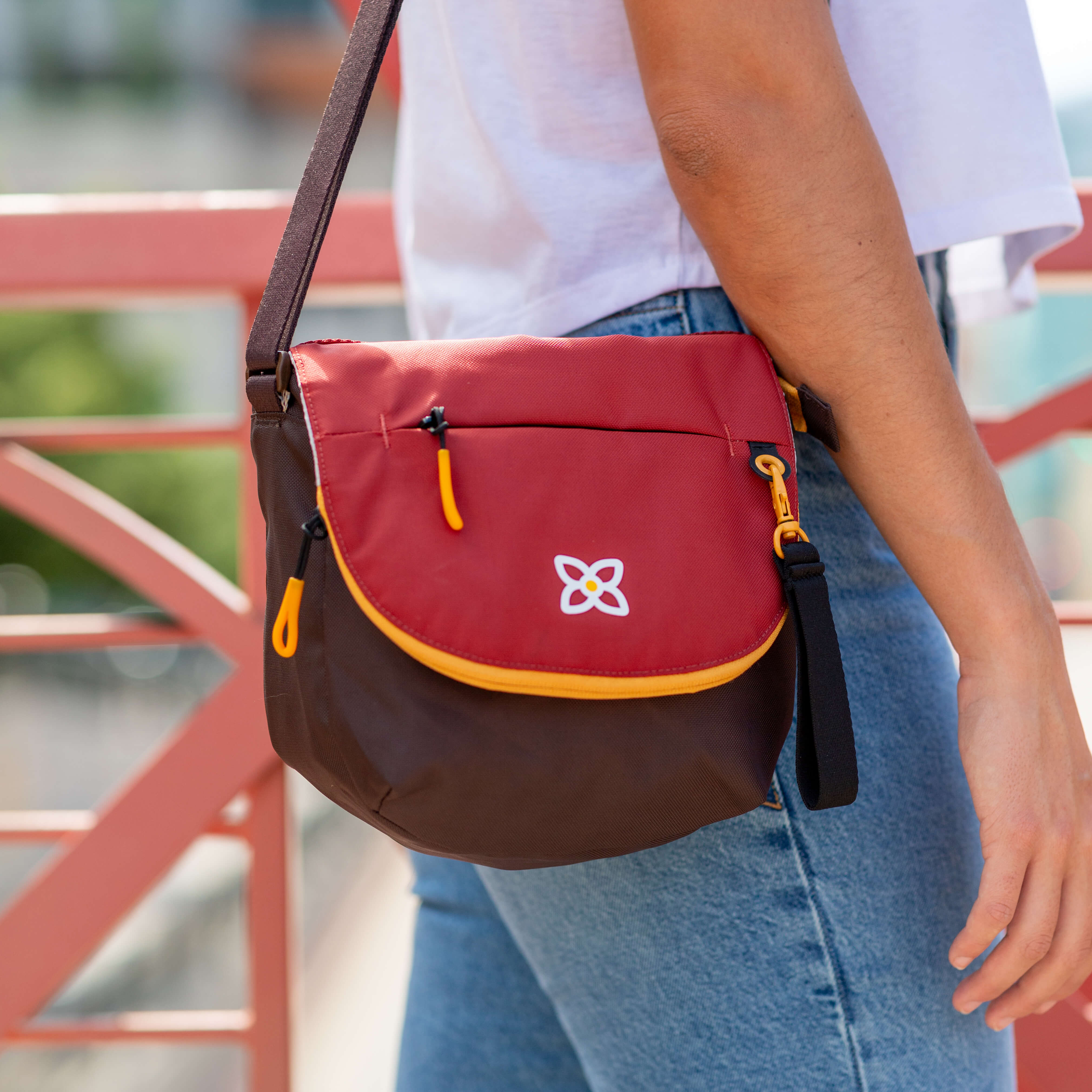 A woman outside is wearing Sherpani crossbody messenger purse, the Milli in Cider. #color_cider