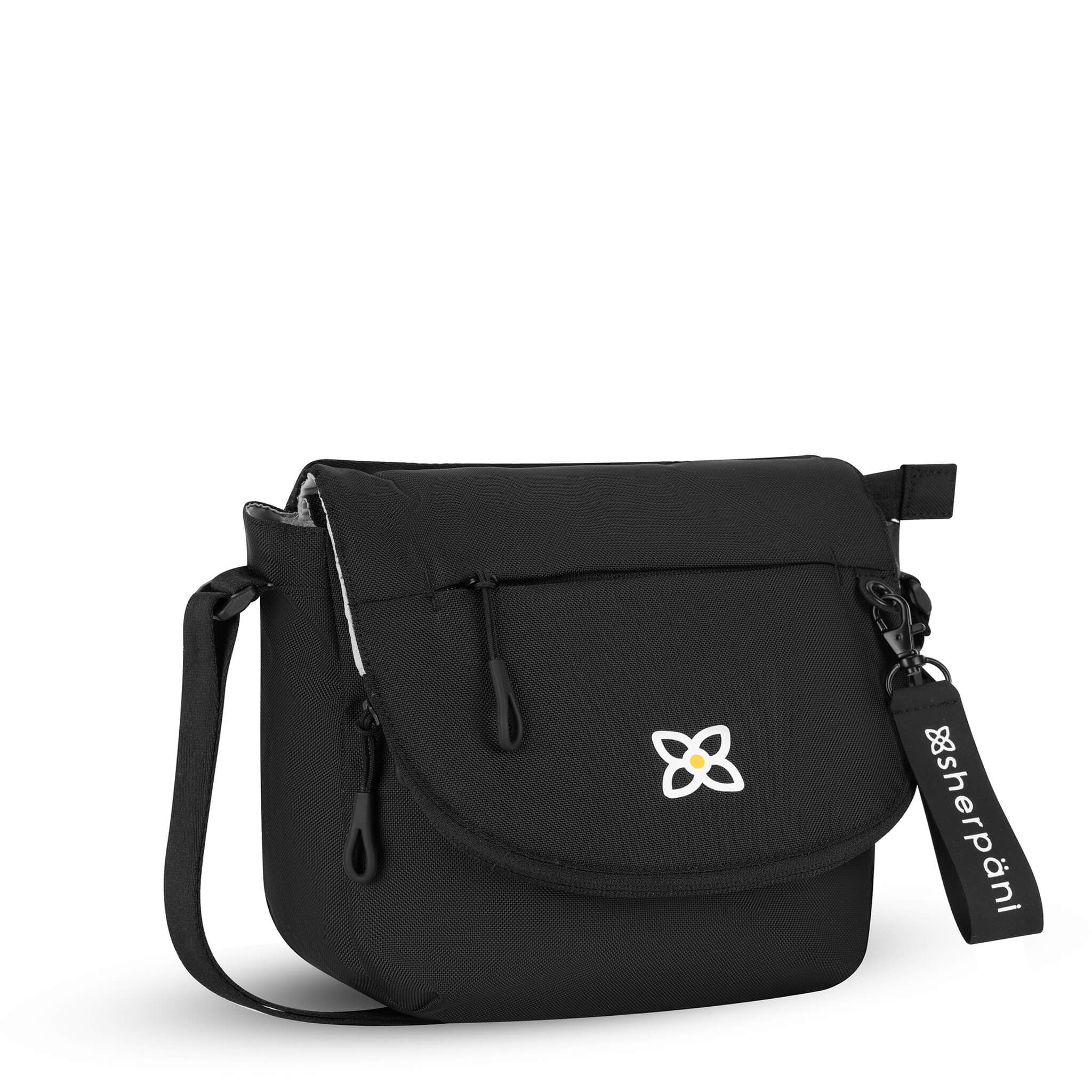 Angled front view of Sherpani messenger satchel bag, the Milli in Raven. Milli features include an adjustable crossbody strap, front zipper pocket, brimmed zipper pocket, detachable keychain, magnetic closure, RFID security and multiple internal pockets for organization. The Raven color is a true black with Sherpani logo (edelweiss flower) accented in white.