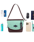 Top view of example items to fill the bag. Sherpani crossbody, the Milli in Seagreen, lies in the center. It is surrounded by an assortment of items: skincare products, sunscreen, beauty spray, car key, passport, phone and Sherpani travel accessory the Barcelona in Seagreen.