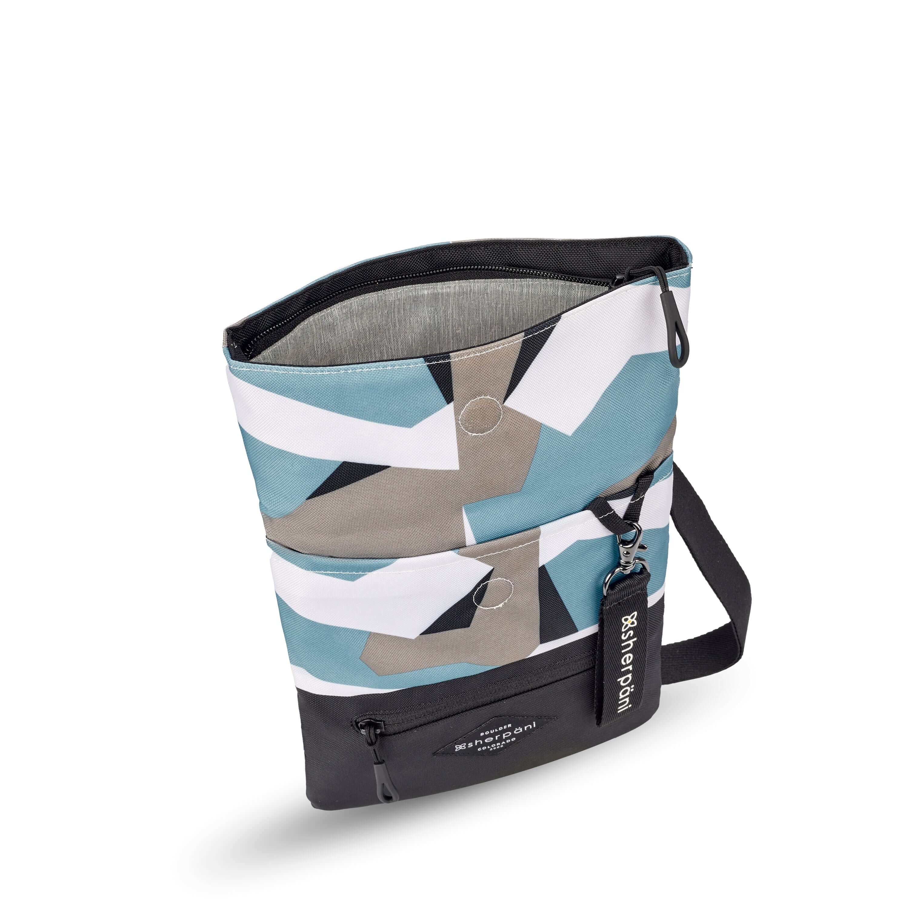 Top view of Sherpani crossbody, the Pica in Summer Camo. The bag is unfolded to stand tall and the main zipper compartment is open to reveal a light gray interior.