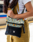 A woman wearing Sherpani bag, the Pica in Fiori, as a shoulder bag.