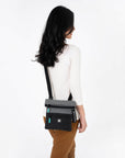 A model wearing Sherpani crossbody travel bag, the Pica in Moonstone.