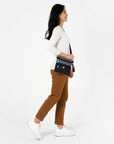 A model wearing Sherpani crossbody travel purse, the Pica in Moonstone.