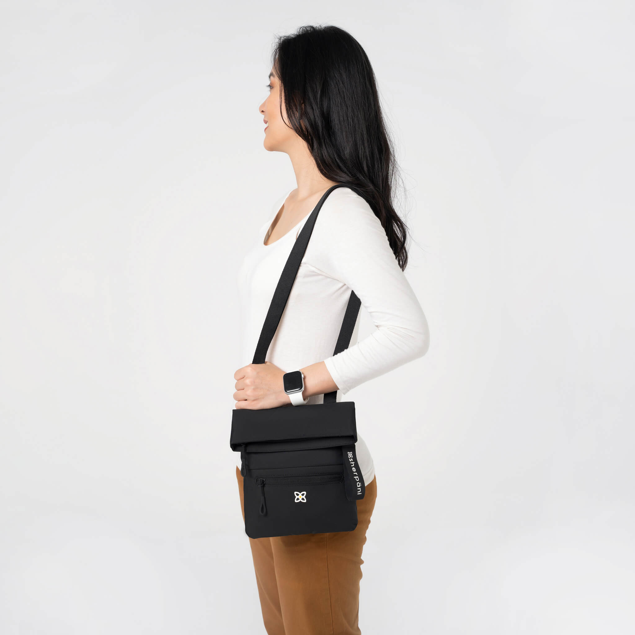 A model showing Sherpani crossbody travel purse with RFID protection, the Pica in Raven. 