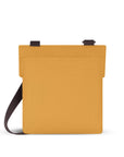 Back view of Sherpani fold over crossbody bag, the Pica in Sundial. Pica features include an adjustable crossbody strap, outside zipper pocket, back flap pocket, inside zipper pocket and slip pocket, detachable keychain and RFID protection. The Sundial coloway is two-toned in yellow and dark brown with turquoise accents.