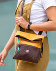 A woman standing outside is wearing Sherpani RFID travel purse, the Pica in Sundial.