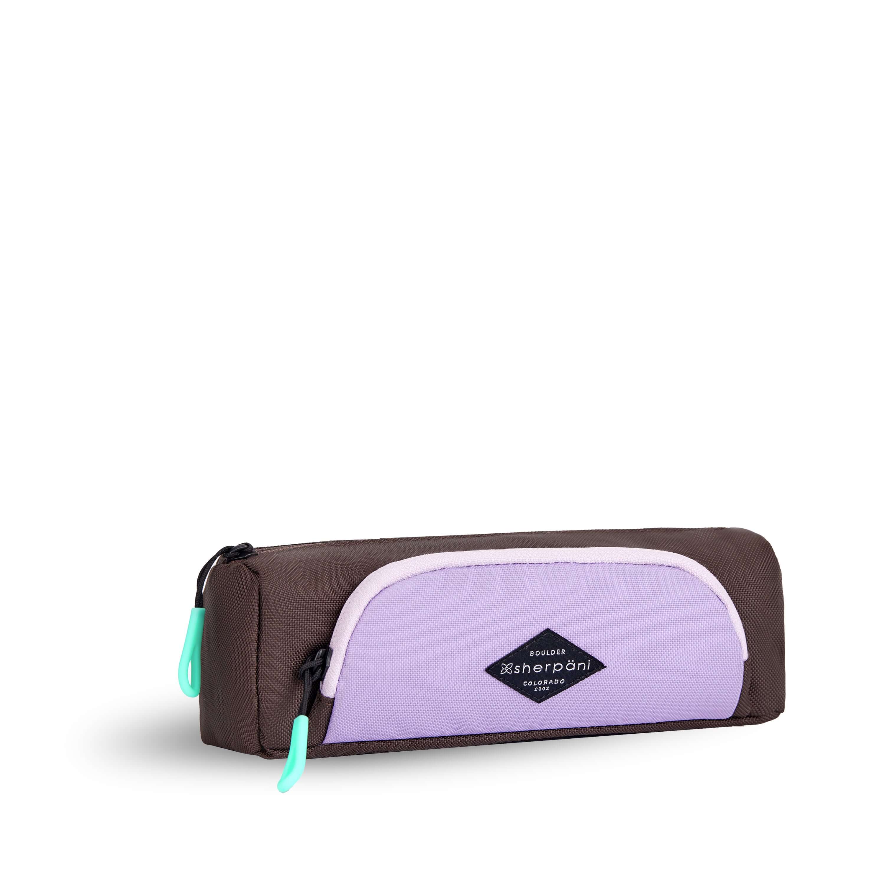 Angled front view of Sherpani travel accessory, the Poet in Lavender. The pouch is two-toned in lavender and brown. There is an external zipper pocket on the front. Easy-pull zippers are accented in aqua.