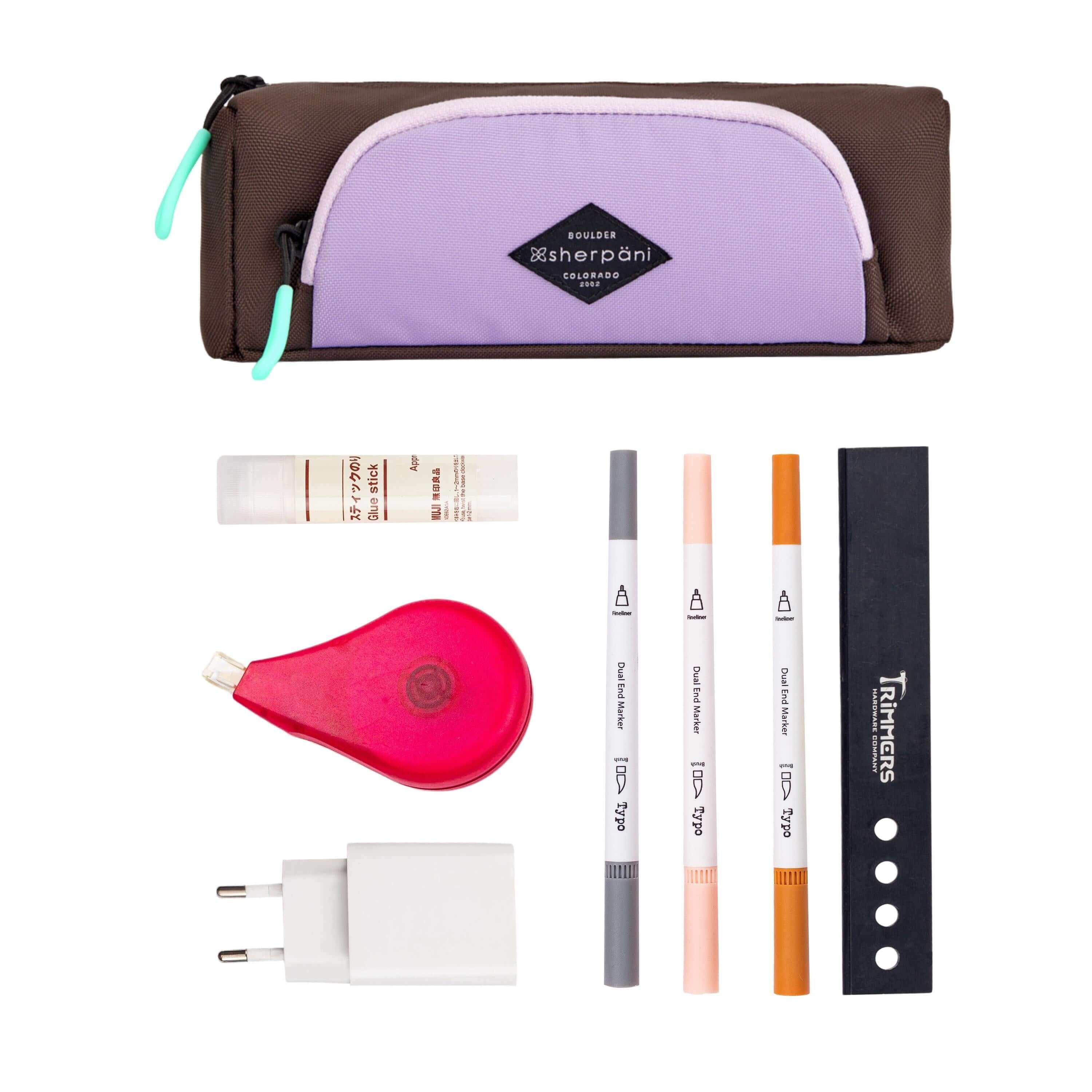 Top view of example items to fill the pouch. Sherpani travel accessory, the Poet in Lavender, lies at the top. Below it are an assortment of items: glue stick, white out, phone charger, markers.