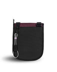 Back view of Sherpani's Anti-Theft bag, the Prima AT in Merlot, with vegan leather accents in black. There is an external pouch on the back of the bag, and a chair loop lock clipped to the left side that is secured in place with an elastic tab.