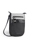 Angled front view of Sherpani’s Anti-Theft bag, the Prima AT in Sterling, with vegan leather accents in black. There is an external pouch on the front of the bag that sits below a locking zipper compartment, which has a ReturnMe tag clipped to it. The bag features an adjustable crossbody strap.