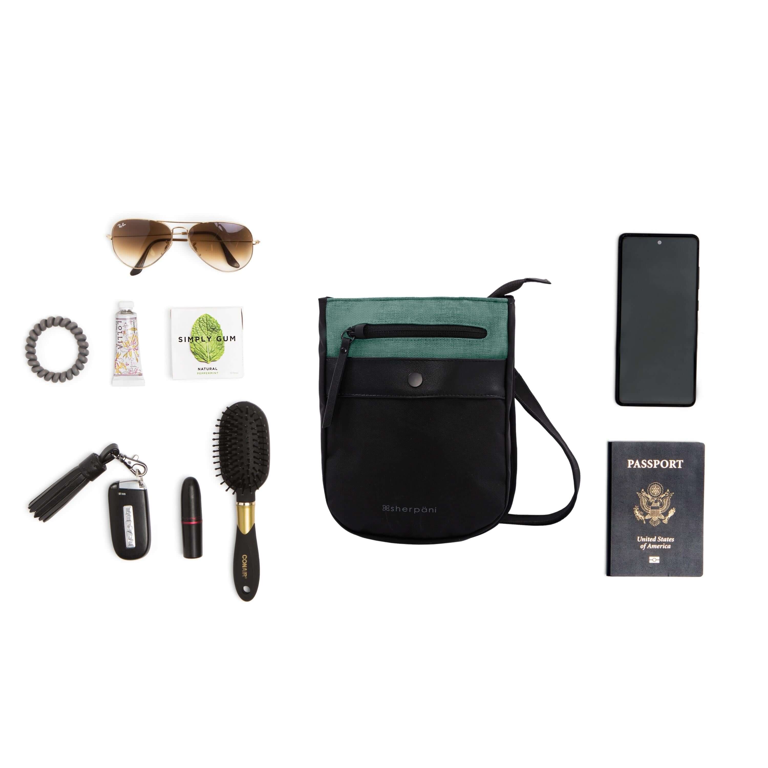 Top view of example items to fill the bag. Sherpani’s Anti-Theft bag, the Prima AT in Teal, lies in the center. It is surrounded by an assortment of items: hairbrush, lipstick, car key, hair tie, lotion, gum, sunglasses, phone and passport.