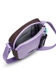 Top view of Sherpani crossbody, the Rogue in Lavender. The main zipper compartment is open to reveal a light gray interior, internal pouch and key fob.