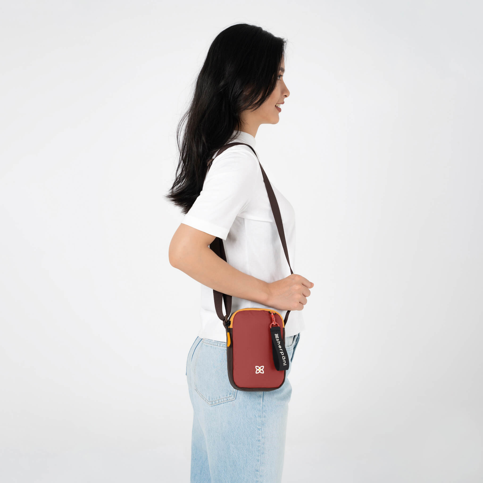A model wearing Sherpani RFID purse, the Rogue in Cider.