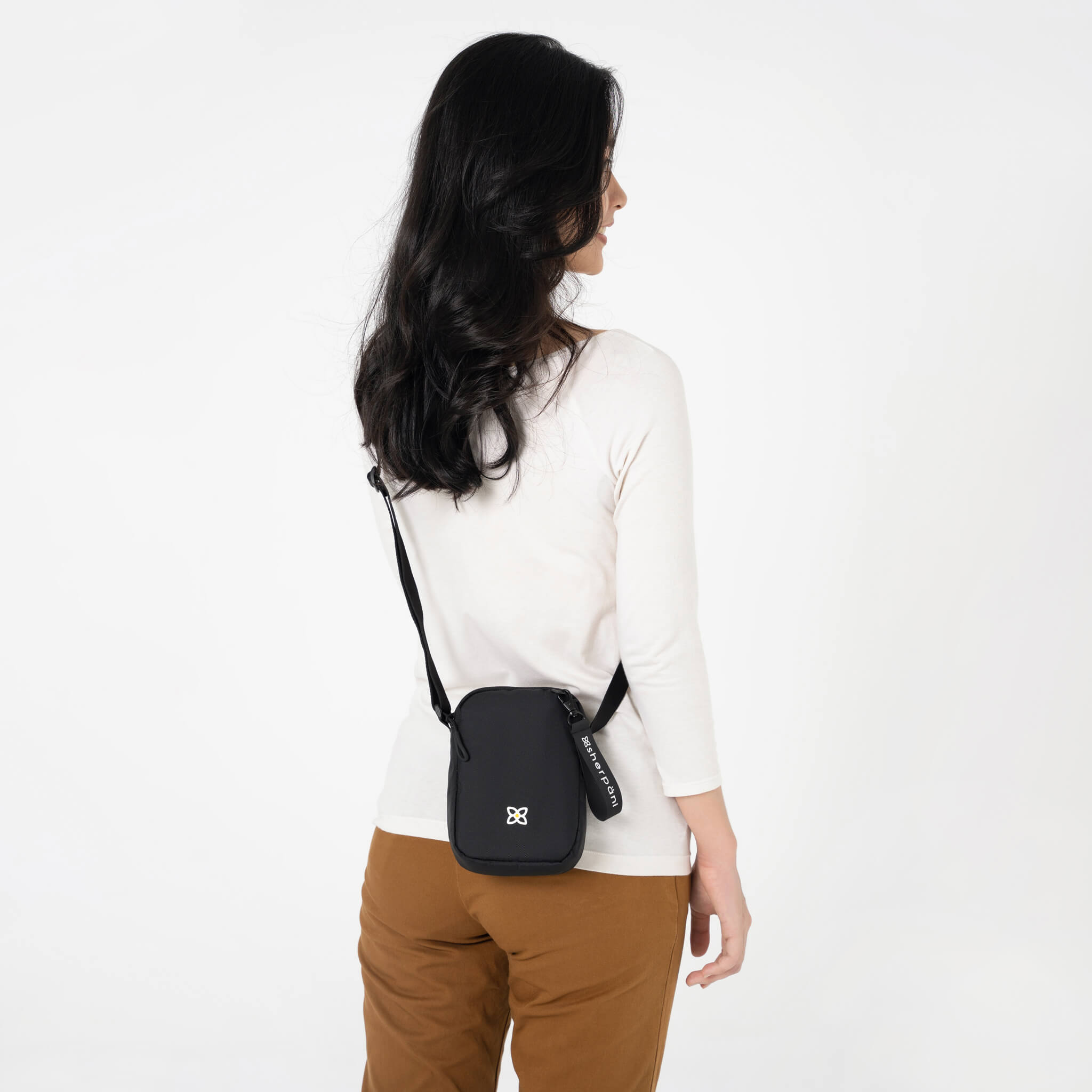 A model showing Sherpani sustainably made bag, the Rogue in Raven.