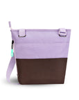 Back  view of Sherpani’s crossbody, the Sadie, in Lavender. The top half of the bag is lavender and the bottom half of the bag is brown. There is an external pocket on the back. A zipper pocket sits on one side with an easy-pull zipper that is accented in aqua. The bag has an adjustable crossbody strap.