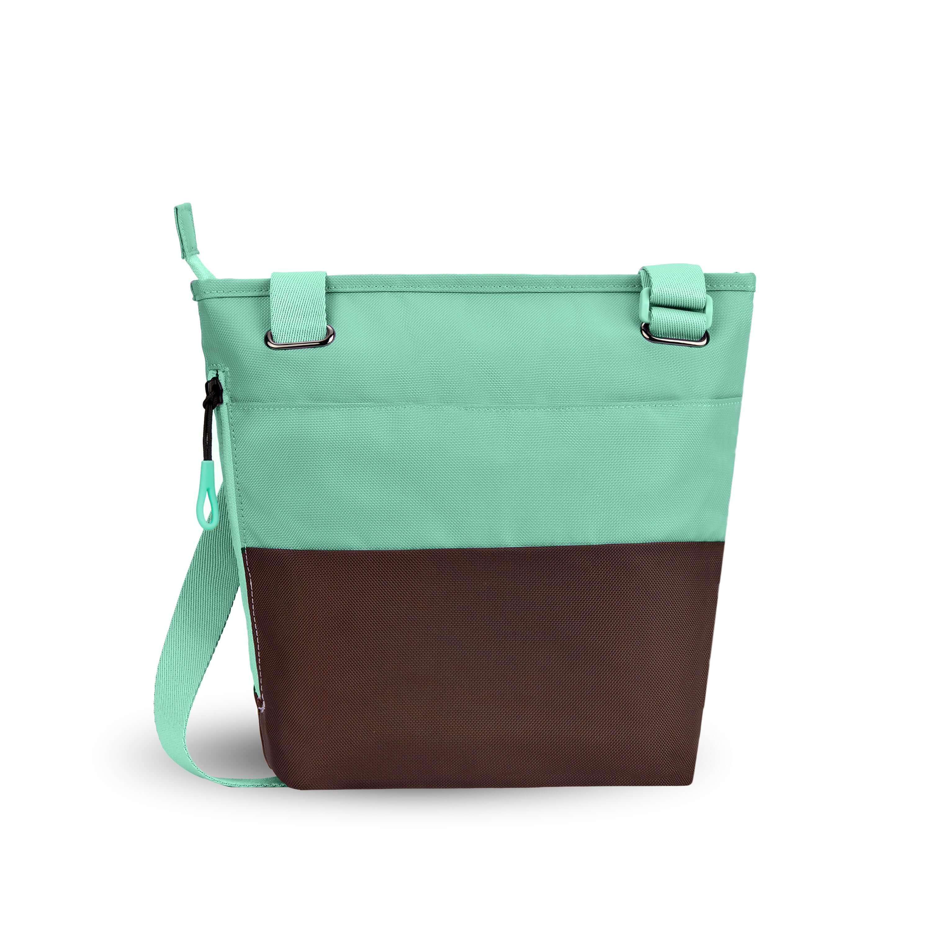 Top view of Sherpani’s crossbody, the Sadie, in Seagreen. The top half of the bag is light green and the bottom half of the bag is brown. There is an external pocket on the back. A zipper pocket sits on one side with an easy-pull zipper that is accented in light green. The bag has an adjustable crossbody strap. 