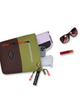 Top view of example items to fill the bag. Sherpani's crossbody, the Sadie in Cactus, lies on its back with an assortment of items spilling out: Sherpani wallet, phone, pencil case, lipstick and sunglasses.