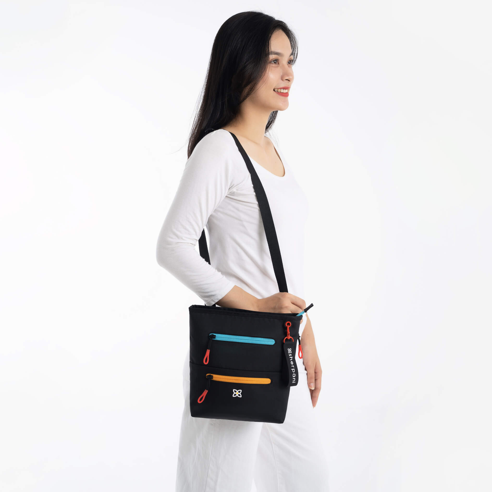 A model wearing Sherpani RFID blocking purse, the Sadie in Chromatic.
