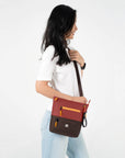 A model wearing Sherpani crossbody travel purse with RFID protection, the Sadie in Cider.