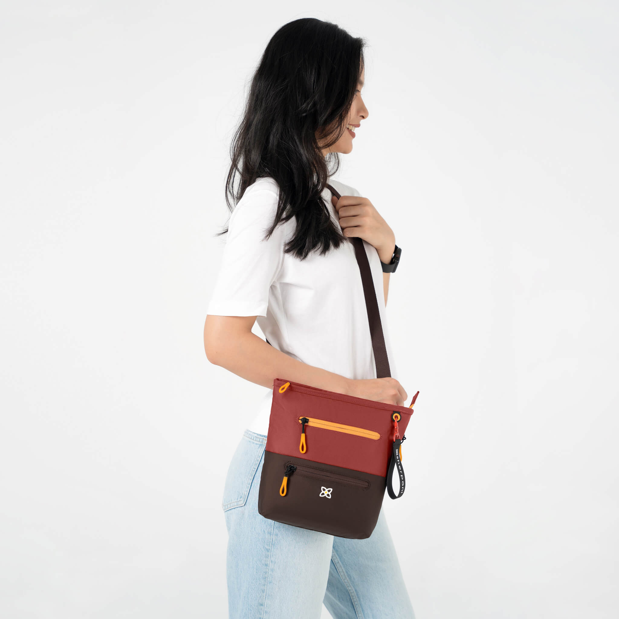 A model wearing Sherpani crossbody travel purse with RFID protection, the Sadie in Cider. 