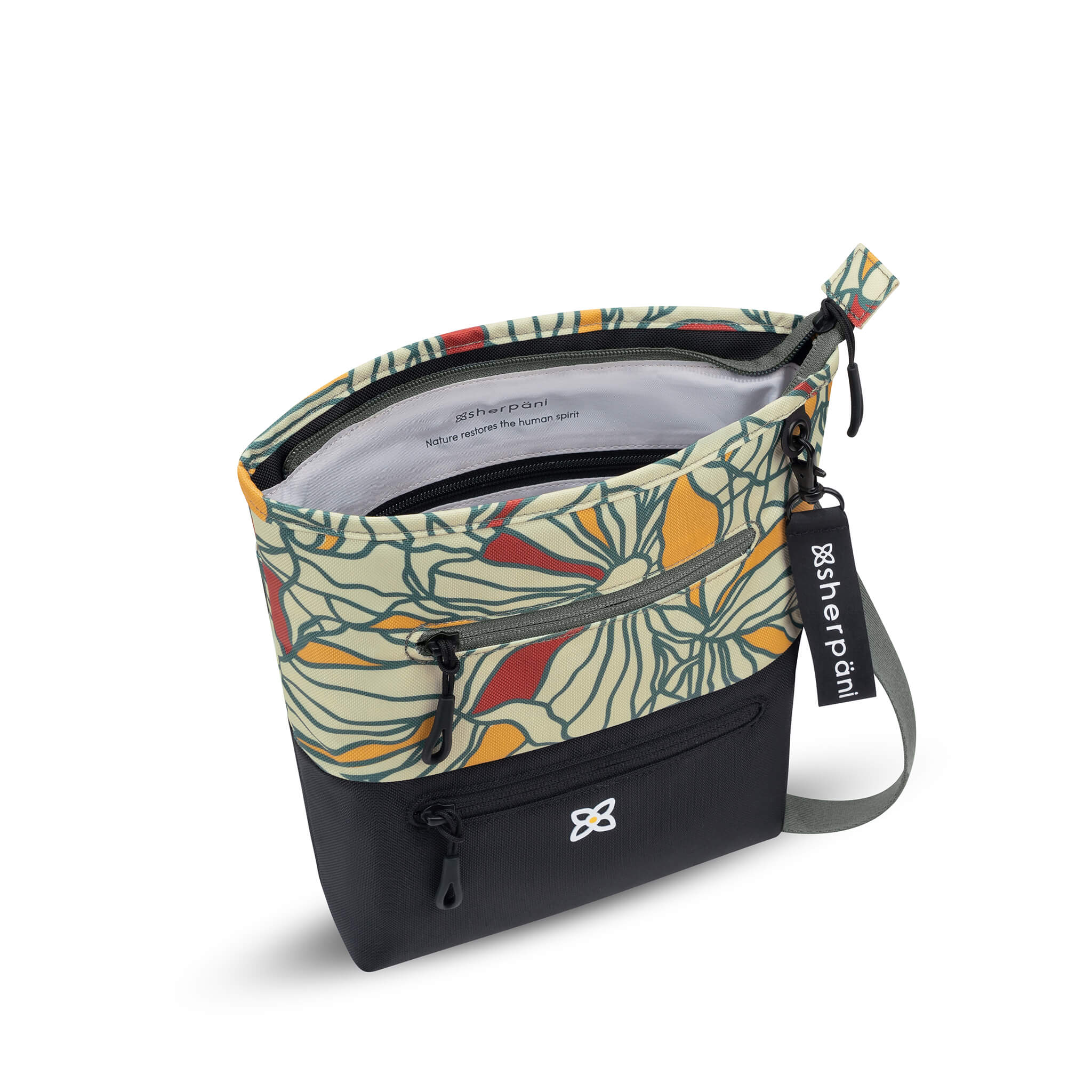 Inside view of Sherpani small crossbody bag, the Sadie in Fiori. The zipper of the main bag compartment is open to reveal internal pockets and text that says &quot;Sherpani: Nature restores the human spirit.&quot;