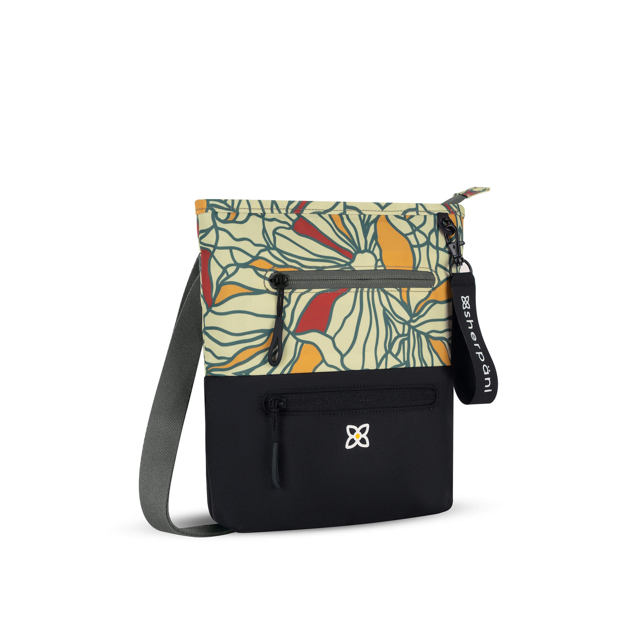 Angled front view of Sherpani crossbody travel bag, the Sadie in Fiori. Sadie features include two front zipper pockets, a discrete side pocket, detachable keychain, adjustable crossbody strap, back slip pocket and RFID blocking technology. The Fiori colorway is two-toned in black and a floral pattern with red accents. 