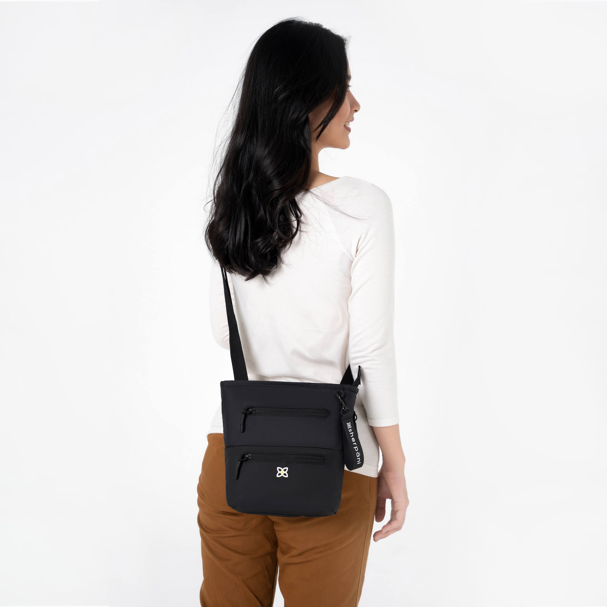 A model wearing RFID blocking crossbody bag, the Sadie in Raven. 