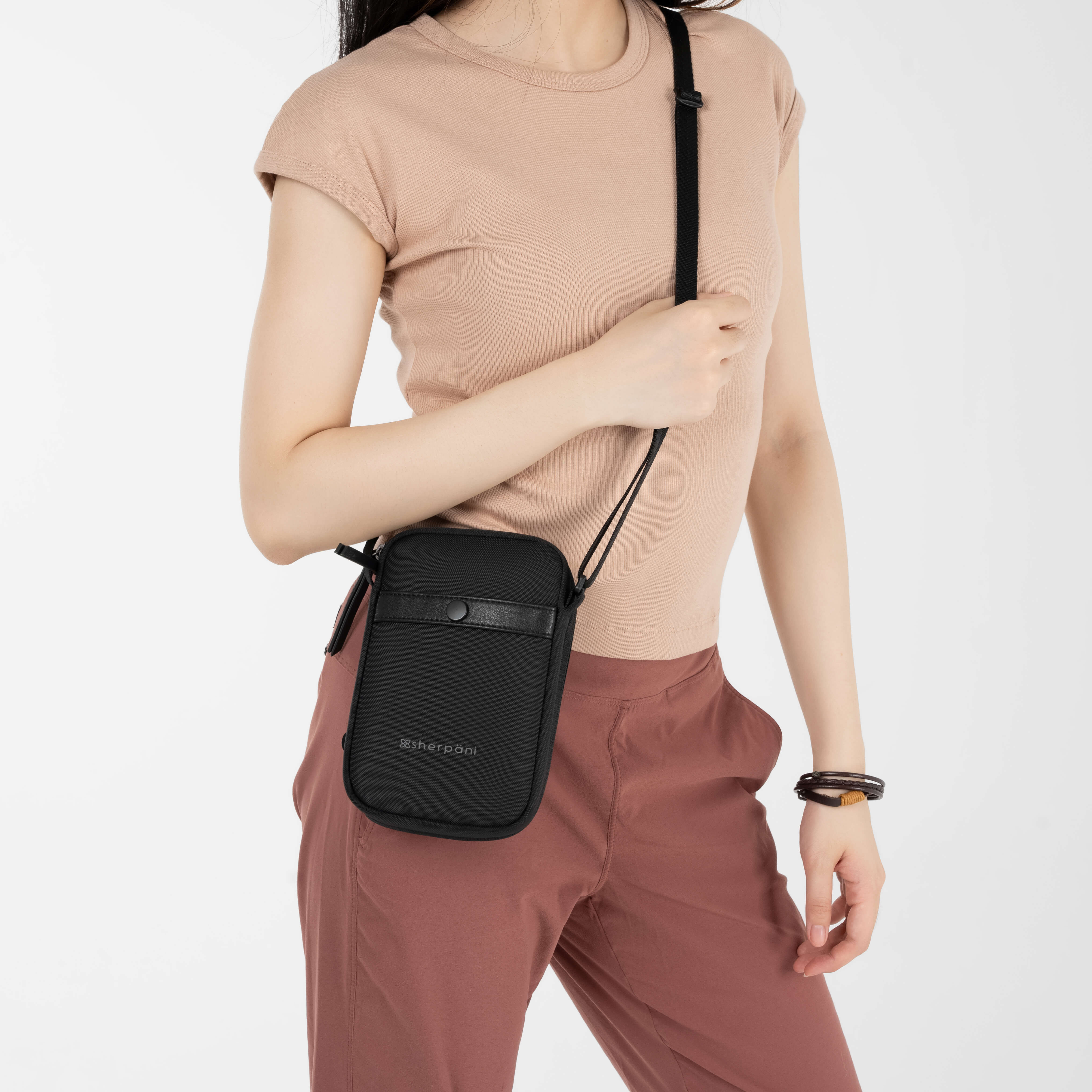 A model wearing women's crossbody wallet, the Simplicity in Carbon. 