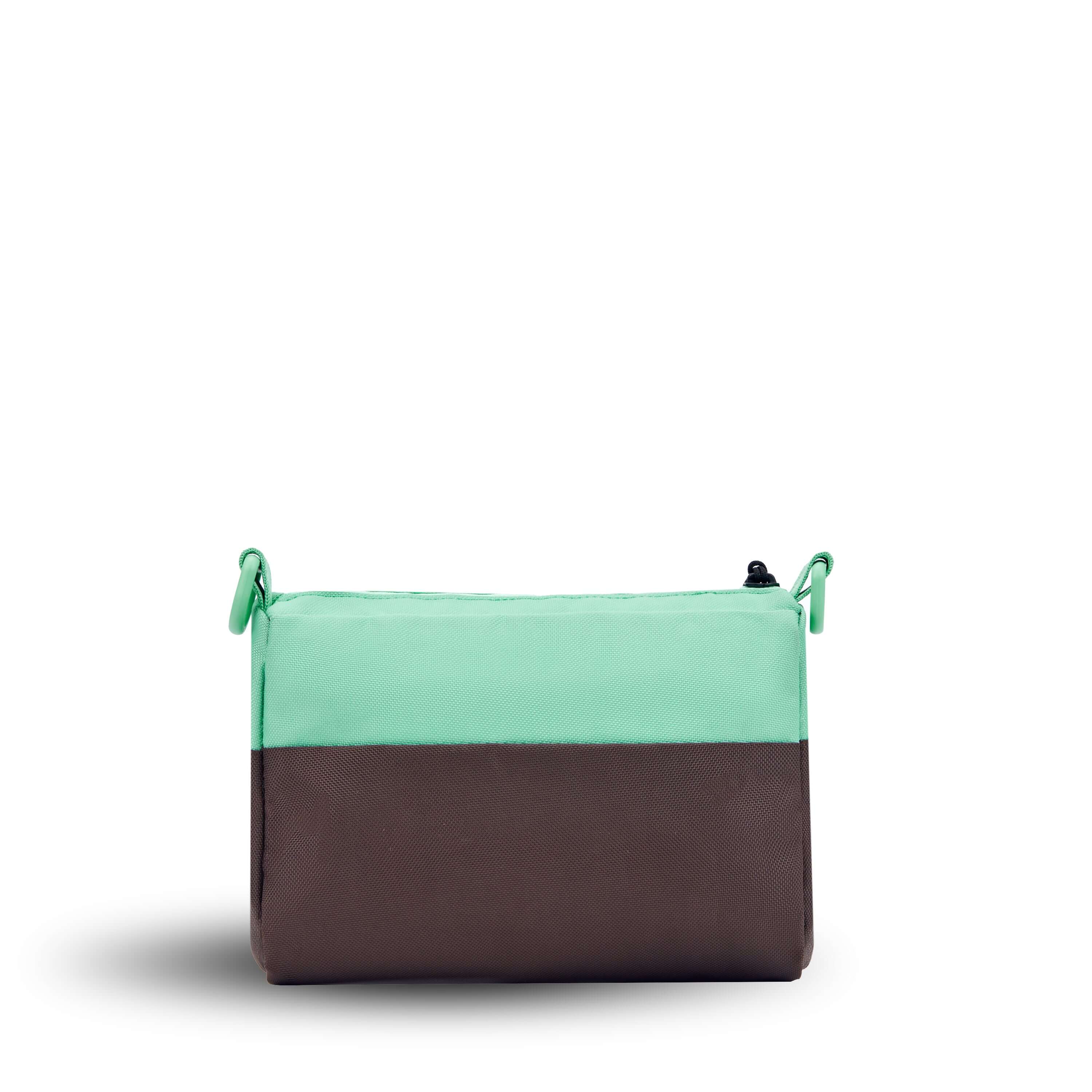 Back view of Sherpani's purse, the Skye in Seagreen. It is two-toned, the top half of the bag is light green and the bottom half of the bag is brown. 