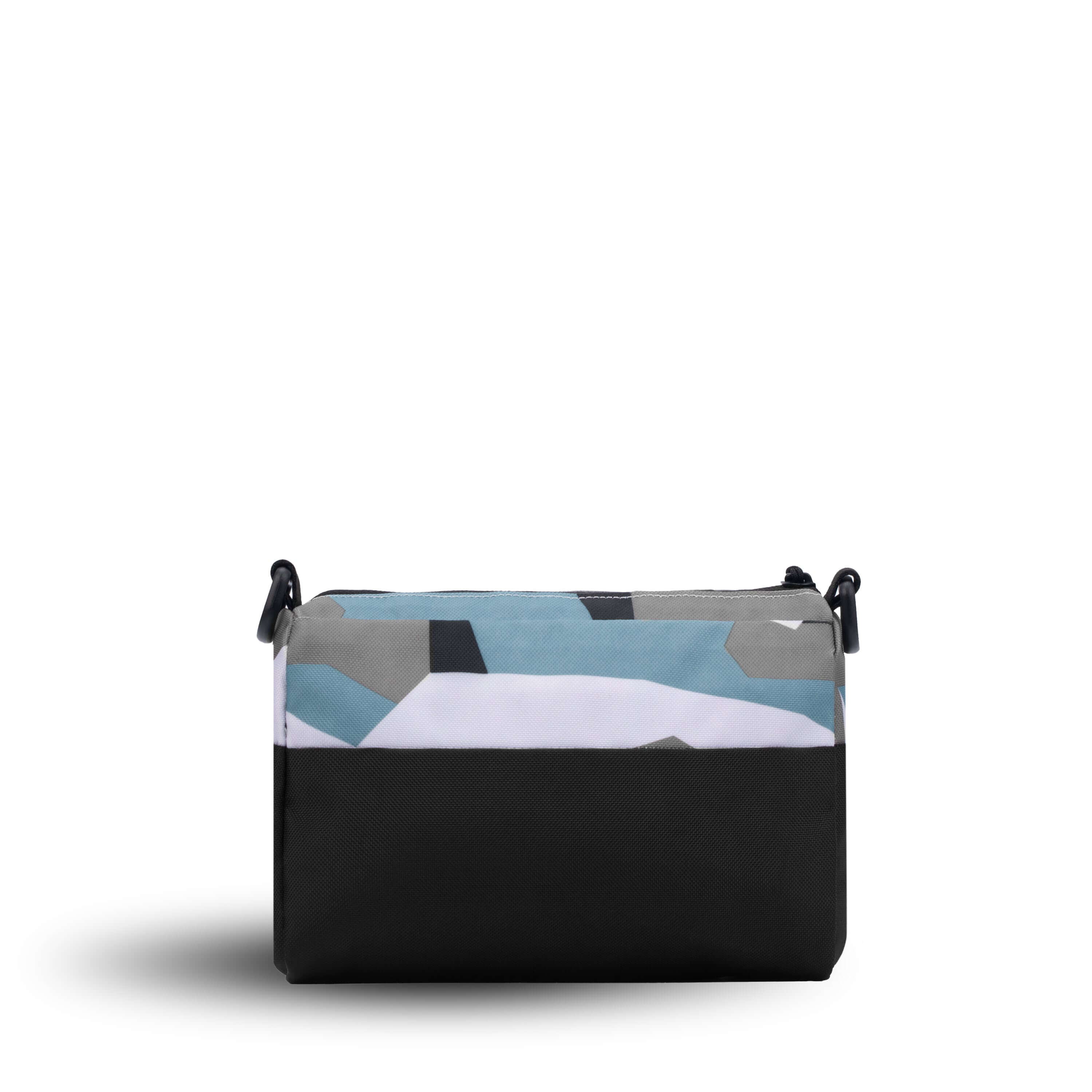 Back view of Sherpani's purse, the Skye in Summer Camo. It is two-toned, the top half of the bag is a camouflage pattern of white, gray and blue, and the bottom half of the bag is black. 