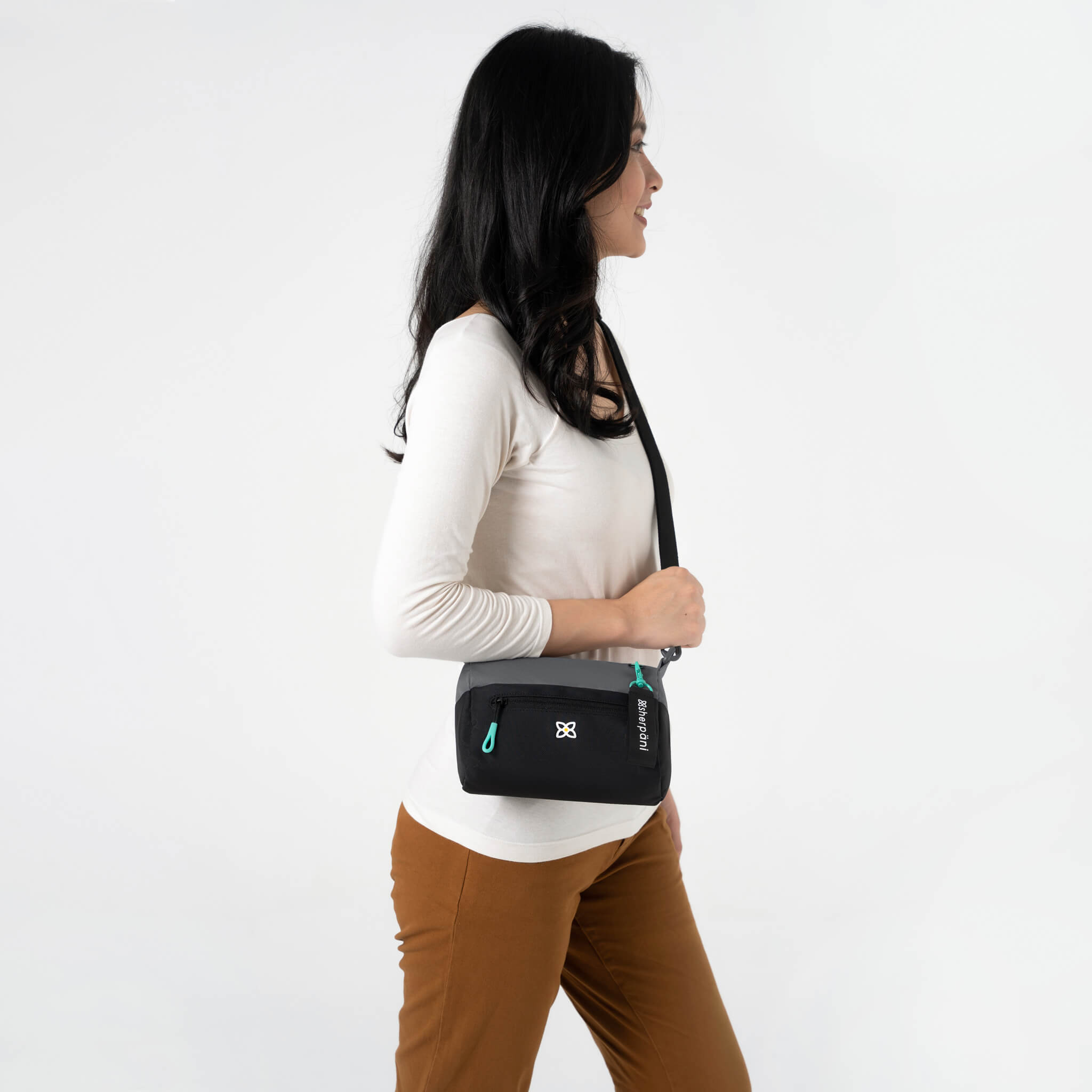 A model wearing Sherpani crossbody bag with RFID protection, the Skye in Moonstone. 