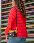 A woman walking outside with Sherpani mini crossbody bag, the Skye in Sundial.