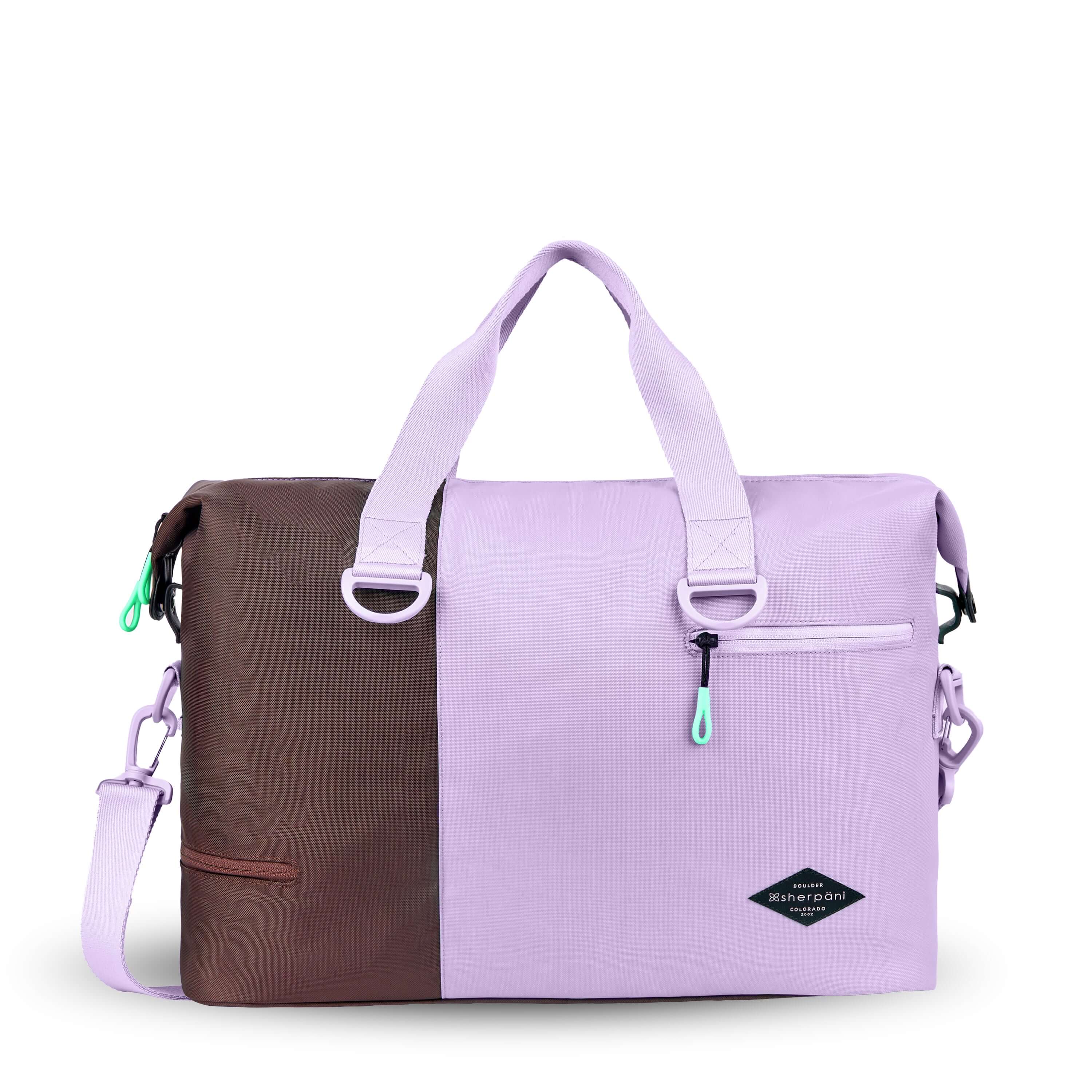 Flat front view of Sherpani bag, the Sola in Lavender. The bag is two-toned in lavender and brown. Two external zipper compartments are visible on the top right and bottom left of the bag. Easy-pull zippers are accented in aqua. The bag has tote handles and an adjustable/detachable crossbody strap.