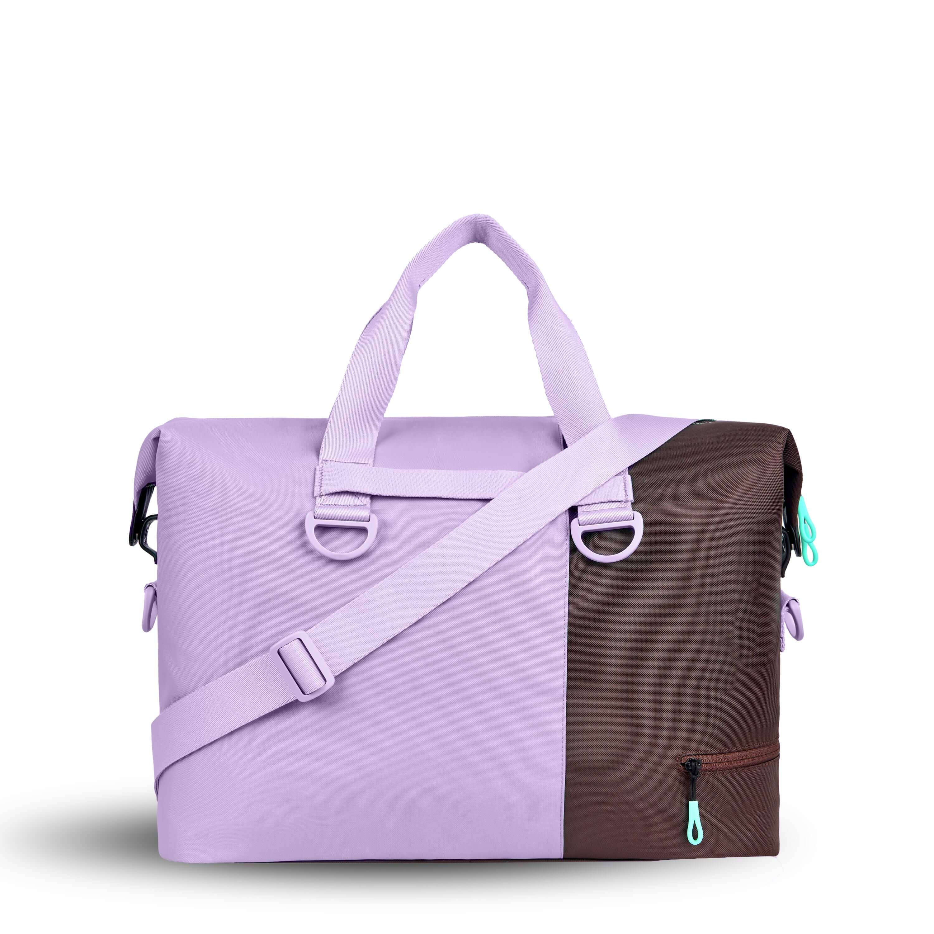 Back view of Sherpani bag, the Sola in Lavender. The bag is two-toned in lavender and brown. Easy-pull zippers are accented in aqua. The bag has tote handles and an adjustable/detachable crossbody strap. 