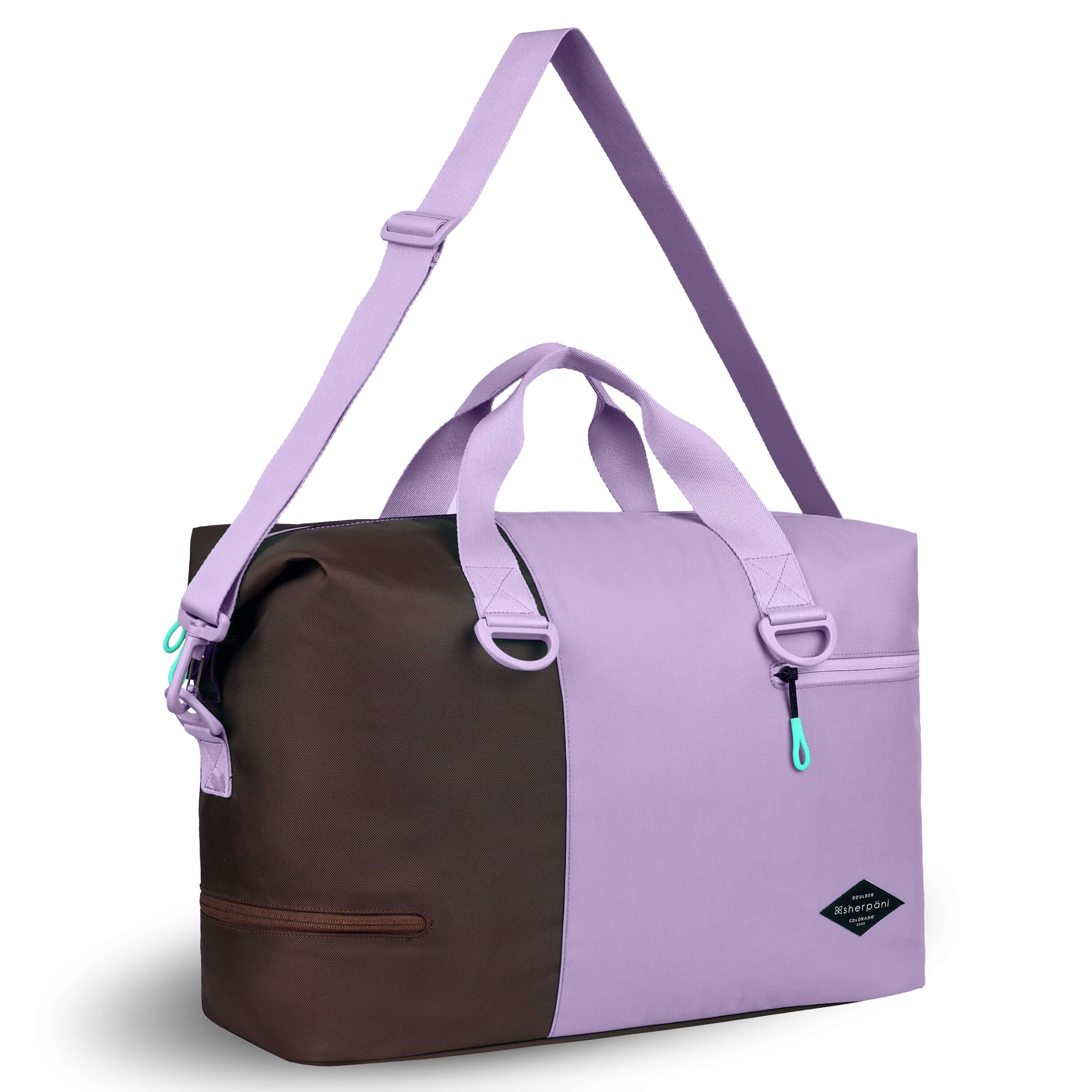 Angled front view of Sherpani bag, the Sola in Lavender. The bag is two-toned in lavender and brown. Two external zipper compartments are visible on the top right and bottom left of the bag. Easy-pull zippers are accented in aqua. The bag has tote handles and an adjustable/detachable crossbody strap.