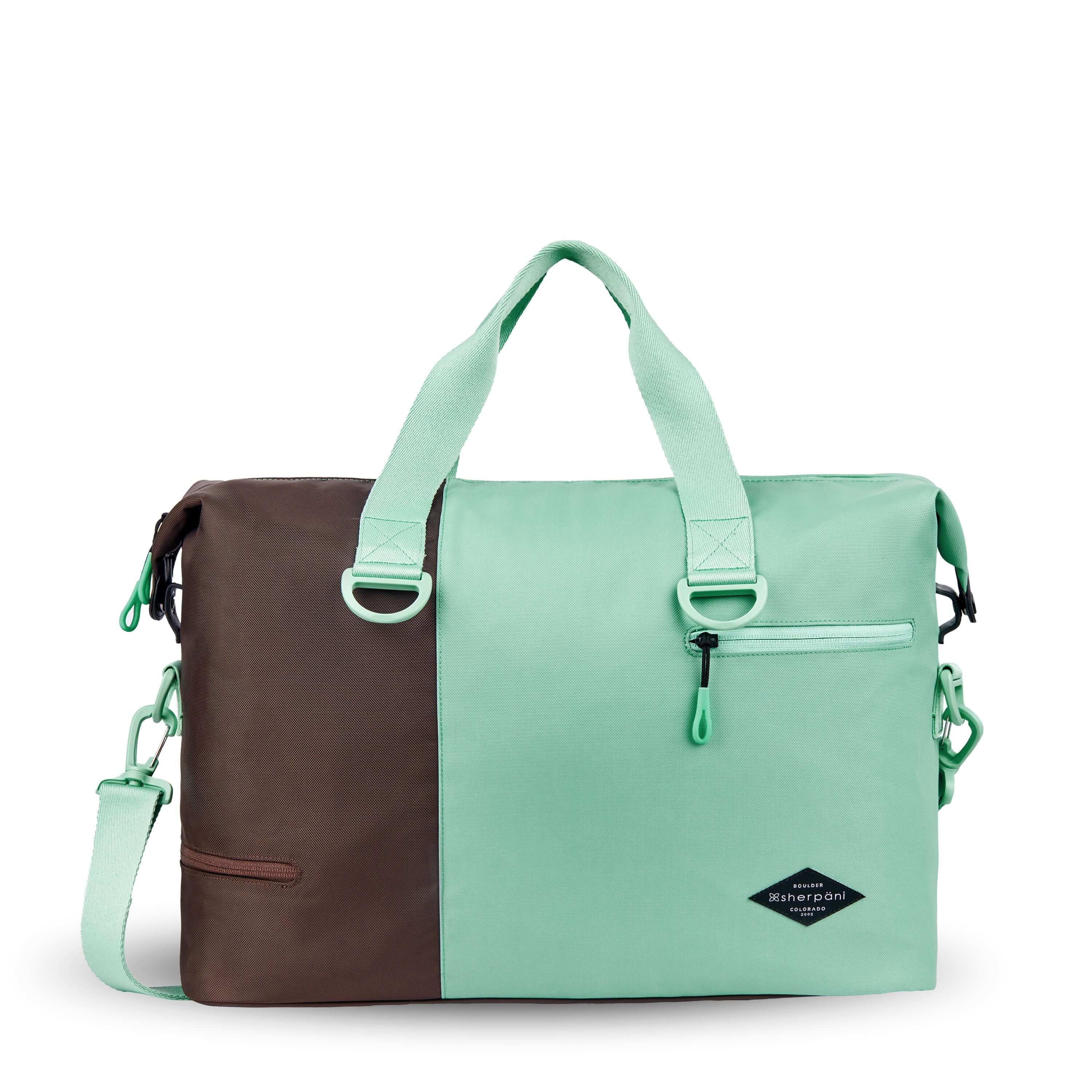 Flat front view of Sherpani bag, the Sola in Seagreen. The bag is two-toned in light green and brown. Two external zipper compartments are visible on the top right and bottom left of the bag. Easy-pull zippers are accented in light green. The bag has tote handles and an adjustable/detachable crossbody strap. 