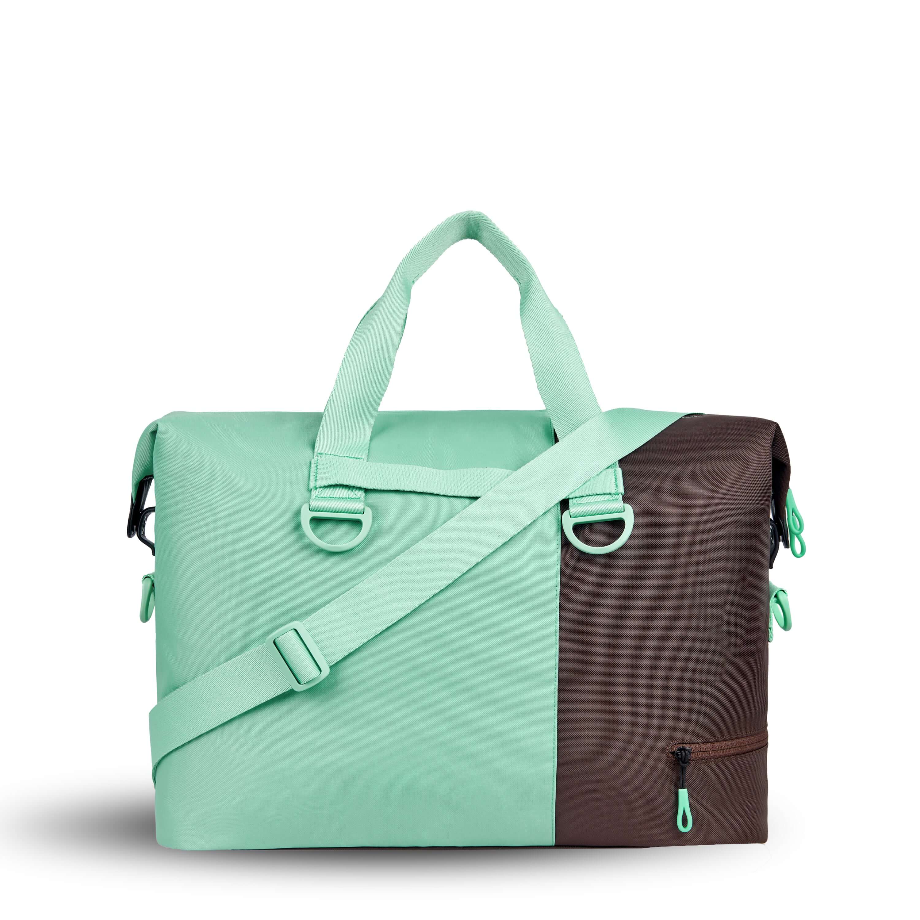 Back view of Sherpani bag, the Sola in Seagreen. The bag is two-toned in light green and brown. Easy-pull zippers are accented in light green. The bag has tote handles and an adjustable/detachable crossbody strap. 