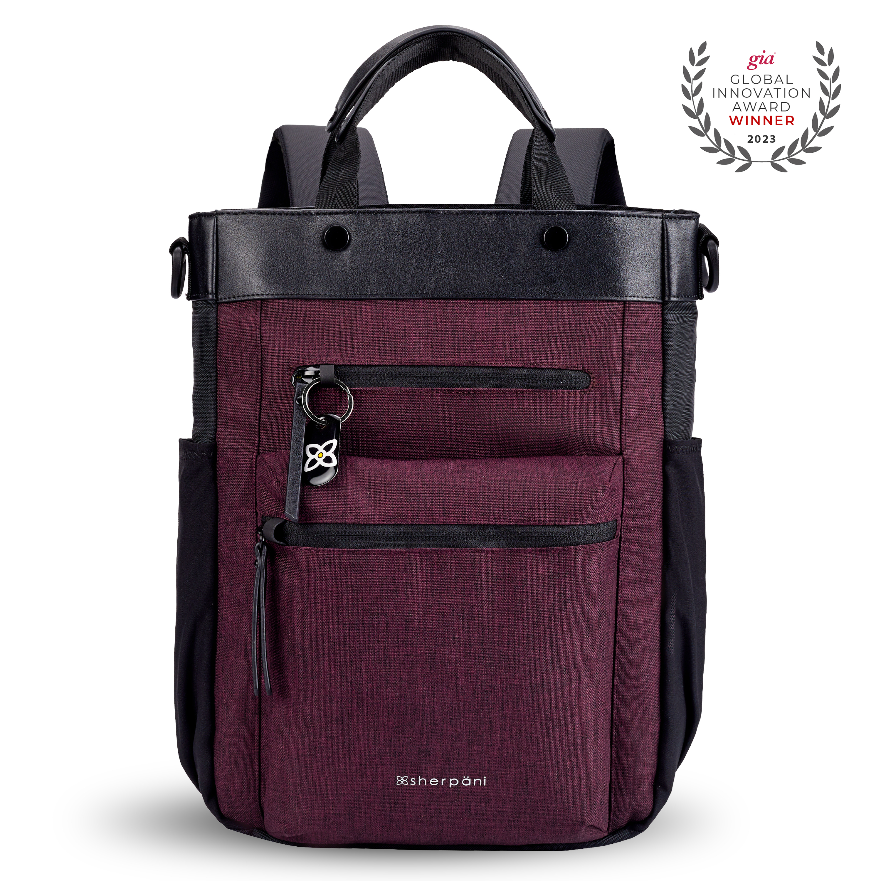 Flat front view of Sherpani&#39;s Anti-Theft bag, the Soleil AT in Merlot, with vegan leather accents in black. On the front are two locking zipper compartments, a ReturnMe tag is clipped to the upper one. Two elastic water bottle holders sit on either side of the bag. It has padded backpack straps, short tote handles, and a place to attach a crossbody strap.