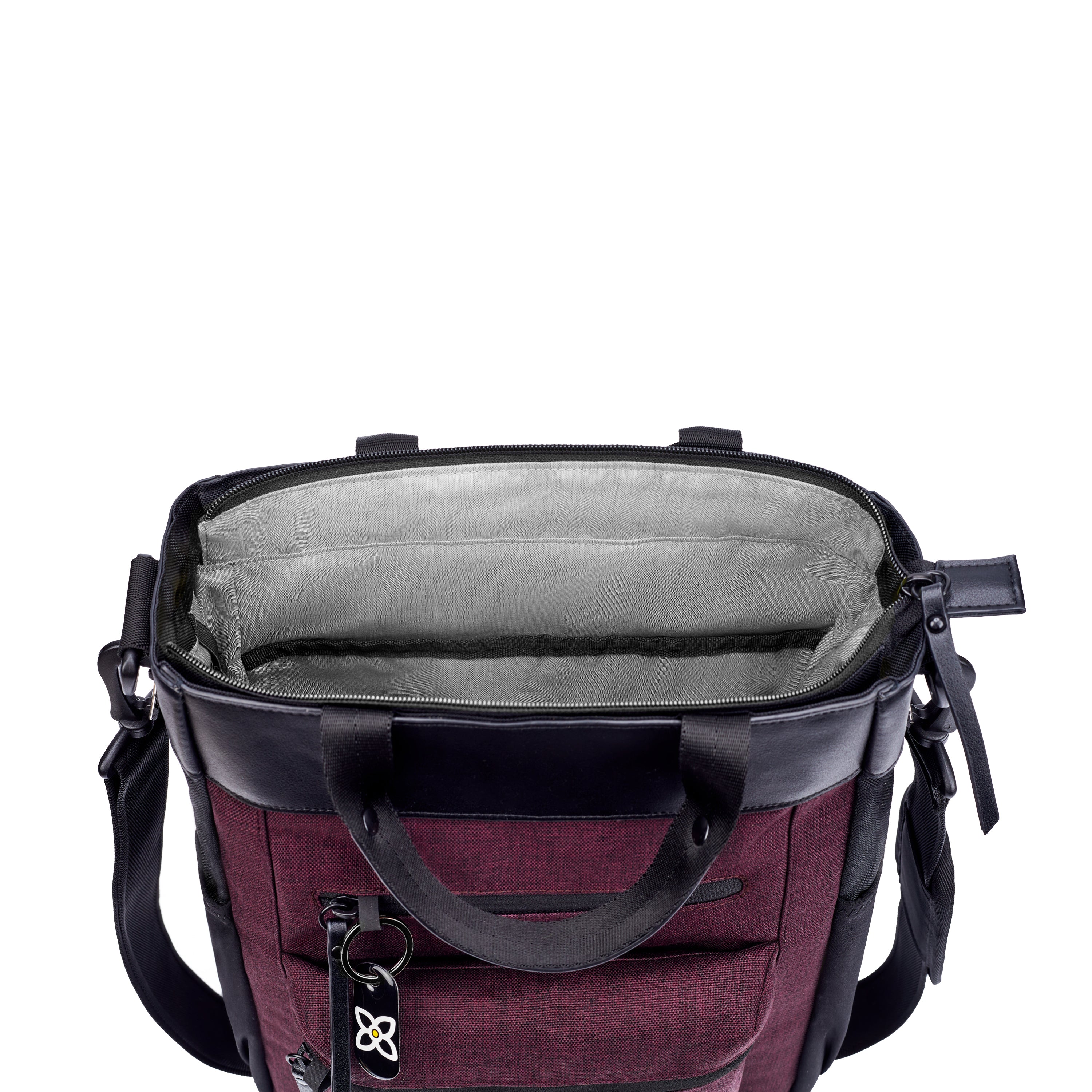 Top view of Sherpani’s Anti-Theft bag, the Soleil AT in Merlot, with vegan leather accents in blag. The mouth of the bag is open to reveal a lime green interior and a padded laptop sleeve. 