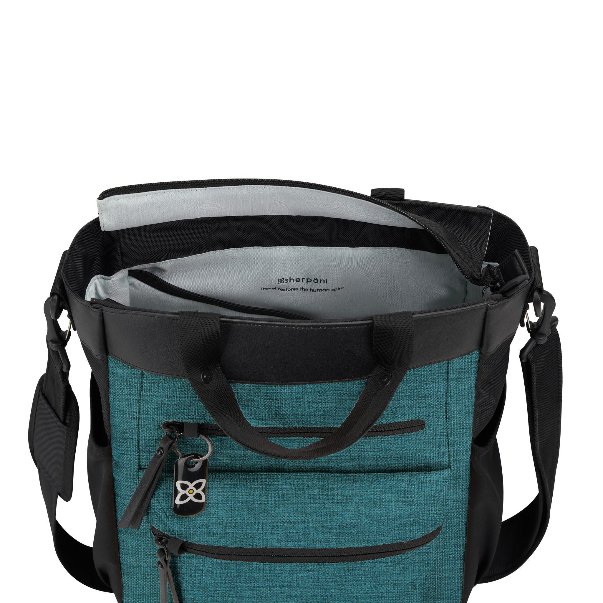 Top view of Sherpani’s Anti-Theft bag, the Soleil AT in Teal, with vegan leather accents in black. The mouth of the bag is open to reveal a pale blue interior and a padded laptop sleeve. 